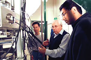 Graduate students Huping Luo (left) and Shaibal Roy flank Milorad P. Dudukovic, Ph.D., the Larua and William Jens Professor of Environmental Engineering and chair of chemical engineering, as they view catalyst particle motion in a slurry system in the Chemical Reaction Engineering Laboratory. Dudukovic is an associate director of the new multi-institutional Center for Environmentally Beneficial Catalysis.