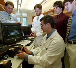 The doctors with joysticks (Eric Leuthardt, seated, and Mathew Smyth, standing) engage in a game of Space Invaders.