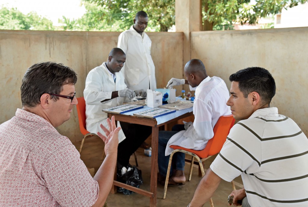 When Washington University researchers, such as Peter Fischer (lower left), PhD, associate professor of medicine, and Joshua Bogus (lower right), MPH, assist in-country partners (background) and cultivate ongoing collaborations, they create a more sustainable model for long-term global impact. (Photo: Issouf Sanogo/Agence France-Presse)