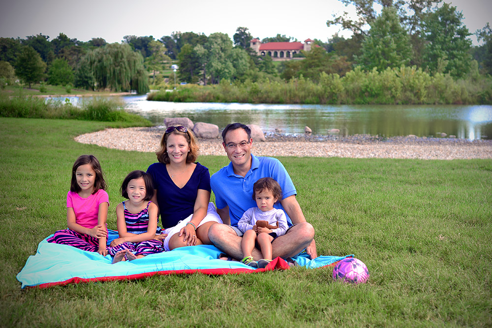 John Inazu relaxes in Forest Park last summer with his wife Caroline, and their children (from left) Lauren, 8, Hana, 6, and Sam, 3. (Photo: James Byard/Washington University)