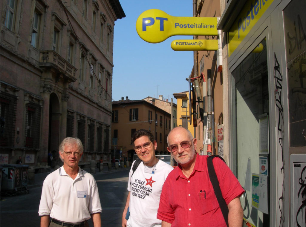 Bender with distinguished fellow physicists Barry McCoy (Stony Brook, left) and Sir Michael Berry (Bristol, right) in Italy looking for evidence that the universe is PT symmetric. The T-shirt reads in Portuguese, If PT is in your heart, I want to talk to you. Courtesy photo.