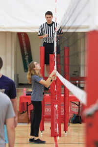 Intramural sports supervisor Sarah Taylor, a senior studying Spanish and urban studies, sets up a volleyball net for the first intramural volleyball game of the season. (Dan Donovan/Washington University)