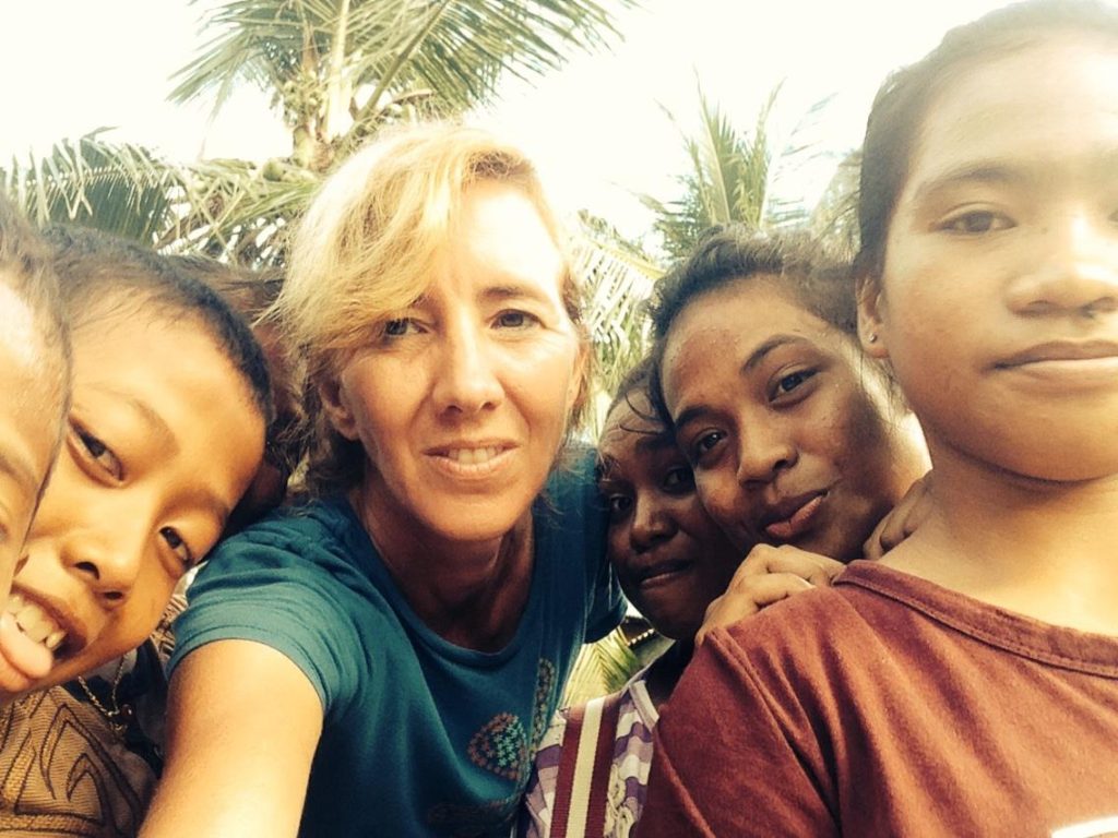 Robin McDowell takes a selfie with kids on the Indonesian island of Benjina, where hundreds of men were being forced to work against their will on Thai fishing trawlers. McDowell avoided the attention of officials for several days by hanging out with village children, practicing English with them. (Courtesy photo)