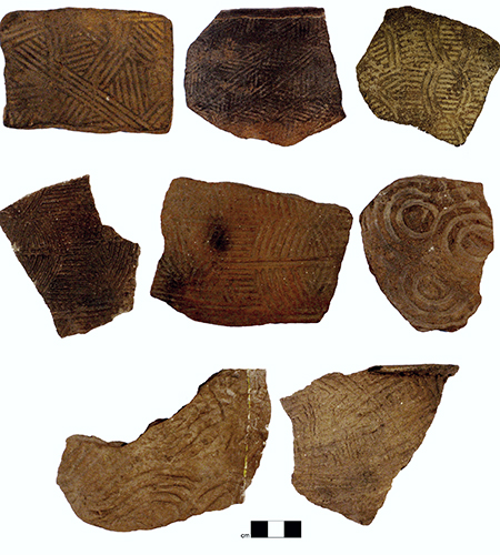 Examples of the kinds of pottery produced by people living across southern Appalachia between AD 800 and 1650. The unique symbols were stamped onto the pottery when the clay was still wet using carved wooden paddles. These designs, along with the varying characteristics of the specific kinds of clay used to produce the pottery, were used to reconstruct social networks among these communities. Photo credit: Jacob Lulewicz.
