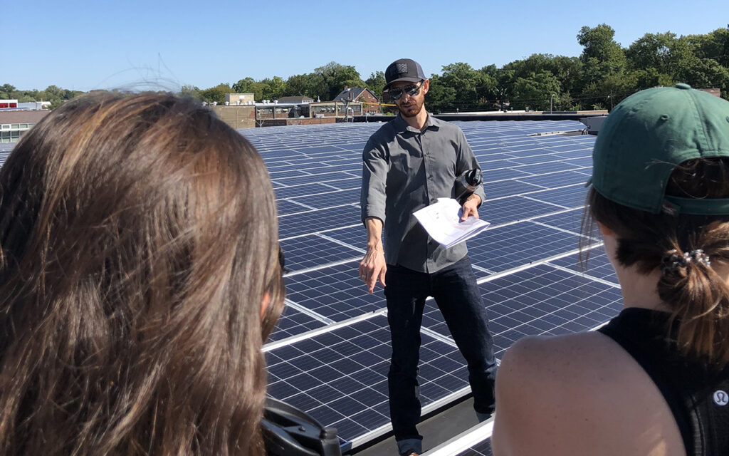 Phil Valko, who studied environment issues while a student at WashU, is  assistant vice chancellor for sustainability at the university. Here, he leads RESET students on a tour of a recently installed solar panel array at WashU’s North Campus. (Photo: Sophia Dossin)