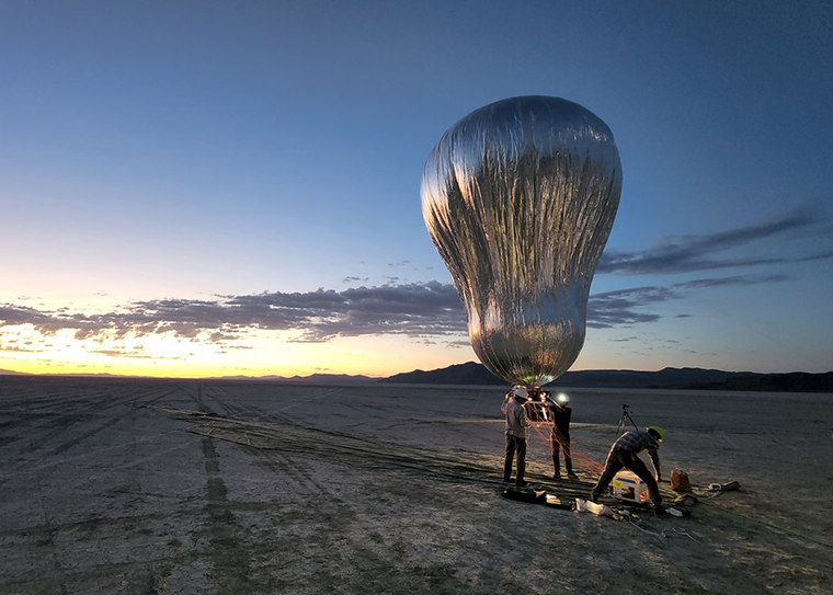 balloon inflating above the desert at sunrise