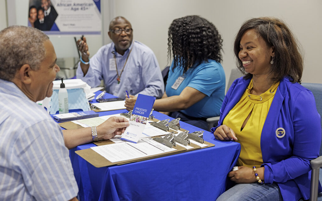 Keisha Windham (right), assistant director of community outreach for the Program for the Elimination of Cancer Disparities, along with Sharvitti Broussard (right, center) and Charles Cogshel (left), attended a health fair at Archwell Health in September to educate members of the community and offer screenings for prostate and colorectal cancers. (Photo: Whitney Curtis/Washington University)