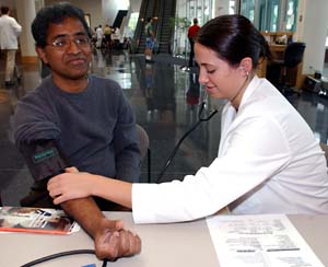 First-year medical student Sahar Masondi takes Ravi Nedella's blood pressure at the student-run mini-clinic on the Medical Campus.