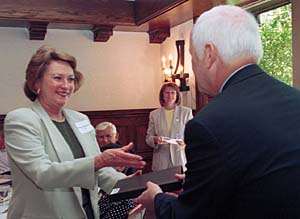 Kathryn Eyerman, who worked at the University for 35 years before retiring, receives a walnut plaque from Larry J. Shapiro, M.D., executive vice chancellor for medical affairs and dean of the School of Medicine, at a recent luncheon at Whittemore House. Forty-six people who retired in fiscal year 2003 were recognized at the event.
