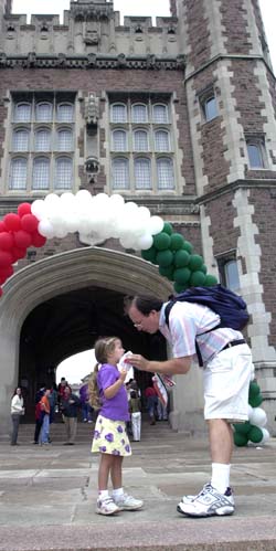 Michael Wysession, Ph.D., associate professor of earth and planetary sciences in Arts & Sciences, lends a helping hand to his four-year-old daughter Elizabeth in front of Brookings Hall.