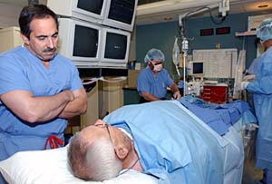 John M. Lasala, M.D., Ph.D., associate professor of medicine, talks with a patient before his procedure in the cardiac catheterization laboratory, which he directs. 