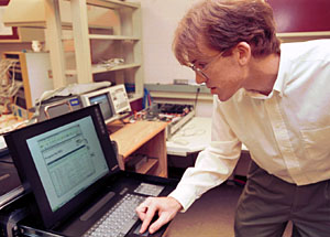 John Lockwood, Ph.D., assistant  professor of computer science and engineering, programs the data enabling device to thwart the SoBig worm. Lockwood and his graduate students have approached the problem of halting worms and viruses via hardware instead of software.  When a virus or worm is detected, the system either can drop the malicious traffic or generate a pop-up message on an end-user's computer.