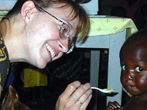 Medical student Heidi Sandige feeds one of the 3,000 children who benefited from the project last year.