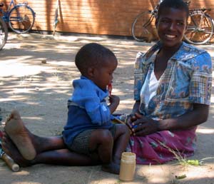 A Malawian mother holds her young son while he eats Mark Manary's peanut butter mixture, which helps an amazing 95 percent of the malnourished children who receive it.