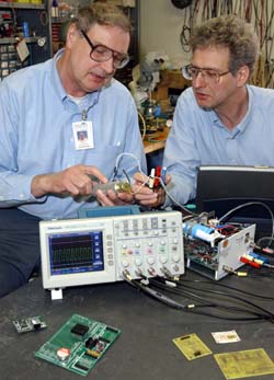 Senior design engineer Arnold Heidbreder (left) and research associate Gavin Perry, Ph.D., work in the Electronics Shop.
