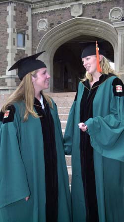 Degree candidates Katie Quinn (left) of the Olin School of Business and Amy Brand of the School of Engineering & Applied Science — and both captains of the national championship Bears volleyball team — wear the green Commencement gowns that are making their full debut at this year's ceremony.