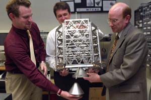 Graduate student Jared G. Macke (left) and faculty members Michael A. Swartwout (middle) and Keith J. Bennett simulate a docking exercise with Bandit - which Macke is holding - docking with its mother ship, *Akoya*. *Bandit* is a 
