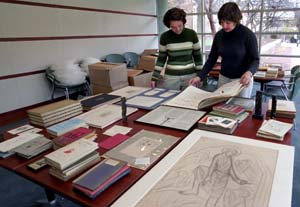 Anne Posega (right), head of Special Collections, and assistant Melissa Vetter admire items from the library's Eric Gill collection. University Libraries has acquired numerous boxes of Gill's artifacts, including books, drawings, alphabets, rubbings, corresondence and woodblocks.