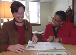 Pam Lokken (left) and Leah Merrifield, director of community relations, look over the most recent issue of the WU Neighbor News, the newsletter issued to area residents.