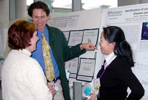 Neurology postdoctoral researcher Yan Hu, Ph.D. (right), discusses her poster presentation on the indentification of candidate biomarkers for Alzheimer's disease with David L. Brody, M.D., Ph.D., instructor of neurology, and Allison C. Gates, Ph.D., postdoctoral research scholar in internal medicine, at the Inaugural Postdoc Scientific Symposium Feb. 23.