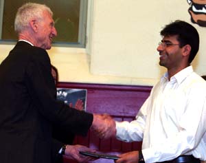 At an April 20 ceremony in Francis Gymnasium, Chancellor Emeritus William H. Danforth (left) presents the full-tuition Elizabeth Gray Danforth Scholarship to Shahrouz Yousefi, a graduate of Forest Park Community College, who spoke no English when he emigrated from Iran just three years ago. He now plans to study electrical engineering. 