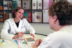 Researcher Tiffany Tibbs discusses breast cancer treatment with a patient.