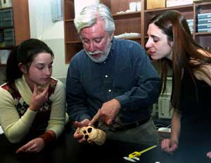 Richard Smith, Ph.D., discusses the finer points of a skull with postdoctoral student Kerrie Lewis, Ph.D. (right), and anthropology graduate student Libby Cowgill.