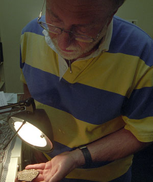 Randy Korotev, Ph.D., research associate professor of earth and planetary sciences in Arts & Sciences, examines fragments of the Sikhote-Alin iron meteorite that fell in Siberia in 1947. The sample is an actual meteorite, but Korotev regularly receives samples from meteorite enthusiasts that are not the real McCoy. Mistakenly identified meteorites have the moniker of 