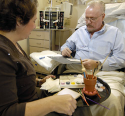 A patient and his wife paint tiles for the Arts as Healing display at Siteman Cancer Center.