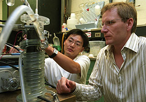 Graduate student Jason He (left) and Lars Angenent, Ph.D., assistant professor of chemical engineering and a member of the University's Environmental Engineering Science Program, work with a version of their microbial fuel cell. The two have developed a new version of the fuel cell that increases the power output by a factor of 10 and are in the planning stages for an even more robust fuel cell.