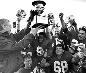 Chancellor William H. Danforth, M.D., presents the championship trophy to the Bears football team. Danforth and his wife, Elizabeth (Ibby) Gray Danforth, were champions of all student activities and were very supportive of the school's athletic programs.