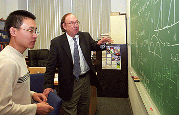 John W. Clark, Ph.D., the Wayman Crow Professor of Physics and chair of physics in Arts & Sciences, works on a problem with Haochen Li, a doctoral student who has been his research assistant for four years and served as his teaching assistant in two courses. 