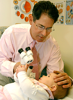 Lawrence Tychsen, M.D., examines Madisen Denman, who has congenital cataracts, before surgery. 