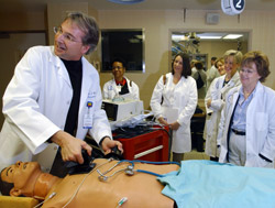 David Murray demonstrates defibrillation techniques to a group of students in the Clinical Simulation Center.