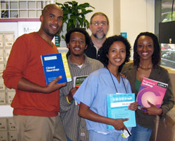 (Left to right) Damien Fair, Binyam Nardos, Sam Craig, Rahel Nardos, and Tracy Nicholson show the books delivered to medical students in Ethiopia.
