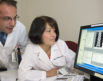 (From left) Nicola Napoli, M.D., research assistant in the Division of Bone and Mineral Diseases, and Reina Armamento-Villareal, M.D., analyze a patient's bone density scan. 