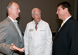 At the 10th anniversary poster session, School of Medicine dean Larry J. Shapiro is flanked by A. Greig Woodring, president and CEO of RGA International Ltd. (left) and Phillip S. Smalley, M.D., RGA's vice president and medical director.