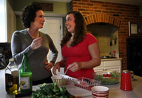 Kathy and Natalie Ferrara prepare dinner. The Ferraras will be interviewed Friday by StoryCorps about Kathy surviving colon cancer.