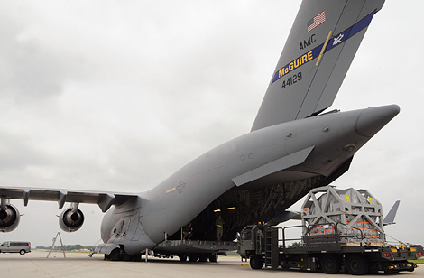 Airmen from Scott Air Force Base load the MRI machine onto a C-17 Globemaster.