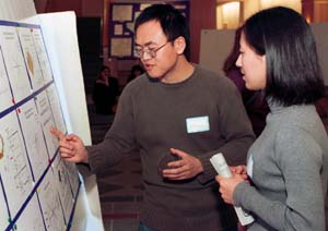 Students Wei Wang and Dongmei Chu discuss a display at the symposium