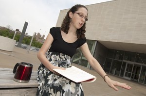 Gellman, who will receive a degree in art history and archaeolgy May 20, reads from a notebook of her poetry outside the Kemper Museum. “Her unusual combination of interests exemplifies the energy, originality and excellence that mark her as one of the most outstanding members of our student community,” says Alicia Walker, PhD, assistant professor and director of undergraduate studies in the Department of Art History and Archaeology in Arts & Sciences.