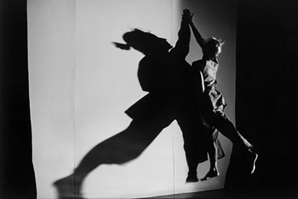 A dancer casts a shadow on a wall