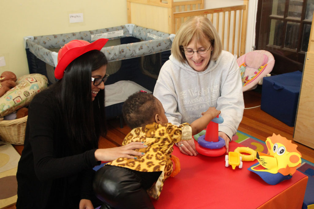 Washington University’s Christine Berg (right) and occupational therapy doctoral student Jaya Bhakta involve preschooler C’dora Gilliam in active play at Our Daycare in Normandy. Occupational Therapy students work with children at the center on a range of developmental activities, among them physical behaviors aimed at preventing obesity and other problems later in life.