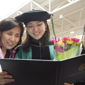 student and family admire her new medical degree