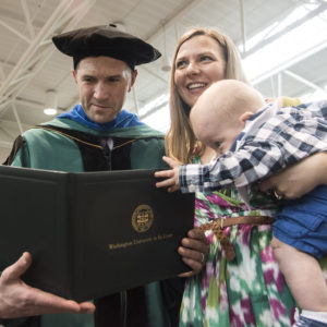 student and family admire new degree