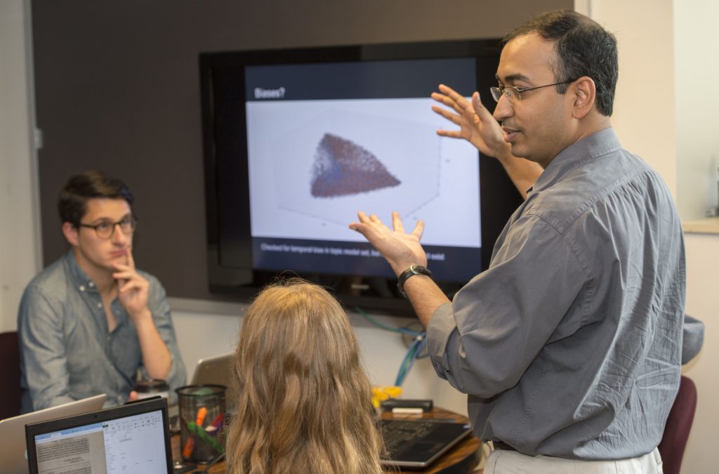Assistant professor Anupam Basu (right) works with students in the Active Learning Classroom in Eads 016. Pictured at left are graduate student John Ladd and recent graduate Keegan Hughes. (Photo: Joe Angeles/Washington University)