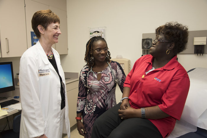 Washington University School of Medicine's Laura Jean Bierut, MD (left), and Foluso Ademuyiwa, MD (center), discuss genetic risks for breast cancer with patient Delores Ford-Dixon. Bierut and Ademuyiwa are launching a study in African-American women with breast cancer to learn whether their genetic risks are influenced by the same mutations that affect white women or are altogether different. (Photo: Robert Boston/School of Medicine)