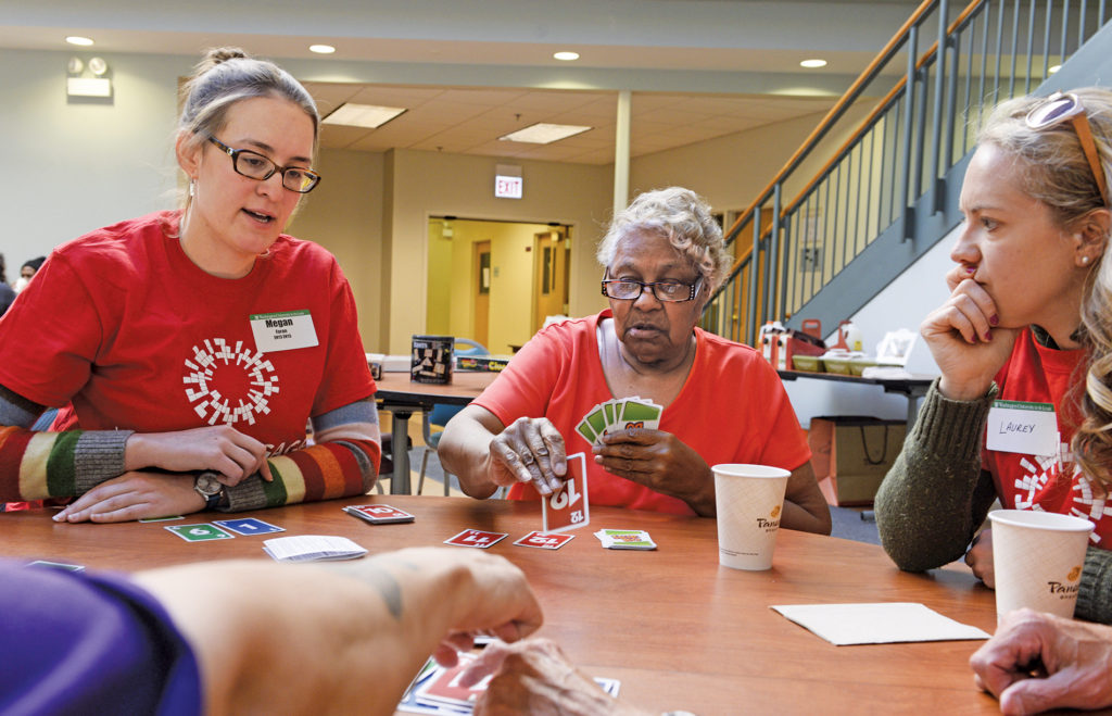 On April 9, 2016, after providing a continental breakfast, 15 alumni volunteers spent the morning getting to know the residents of St. Brendan Apartments, a senior independent housing facility ­affiliated with Catholic Charities of the ­Archdiocese of Chicago. Alumna Megan Foran (left), BSME ’13, BSAS ’13, was among those playing cards with Barbara Tisdale (center), a resident of St. Brendan Apts. (Matt Marton/WUSTL Photos)