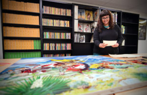 Skye Lacerte, the curator of the Modern Graphic History Library Curator, inspects the Walter Baumhofer Collection. (James Byard/WUSTL Photos)