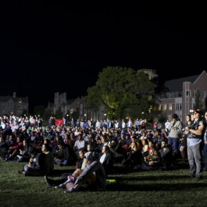 students on lawn watch the debate